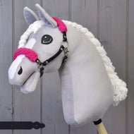 A grey plush Hobby Horse with a white blaze and braided mane wears the black halter with curly bright pink fur