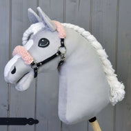A grey plush Hobby Horse with a white blaze and braided mane wears the black leatherette halter with old rose fur