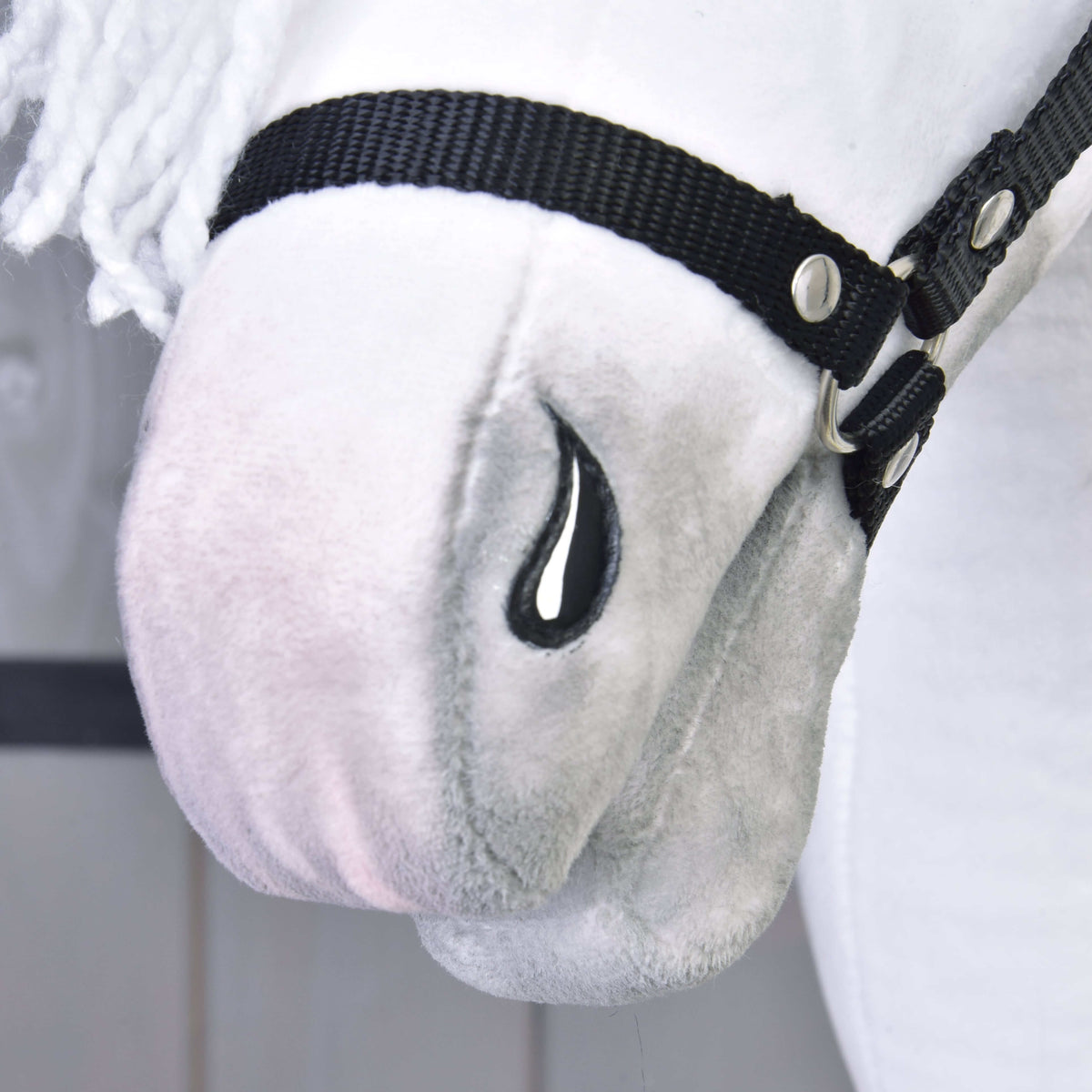 Närbild av den mjukt gråskuggade mulen på Hobby Horse Elektra, sydd svart näsborre och den svarta grimmans nosrem