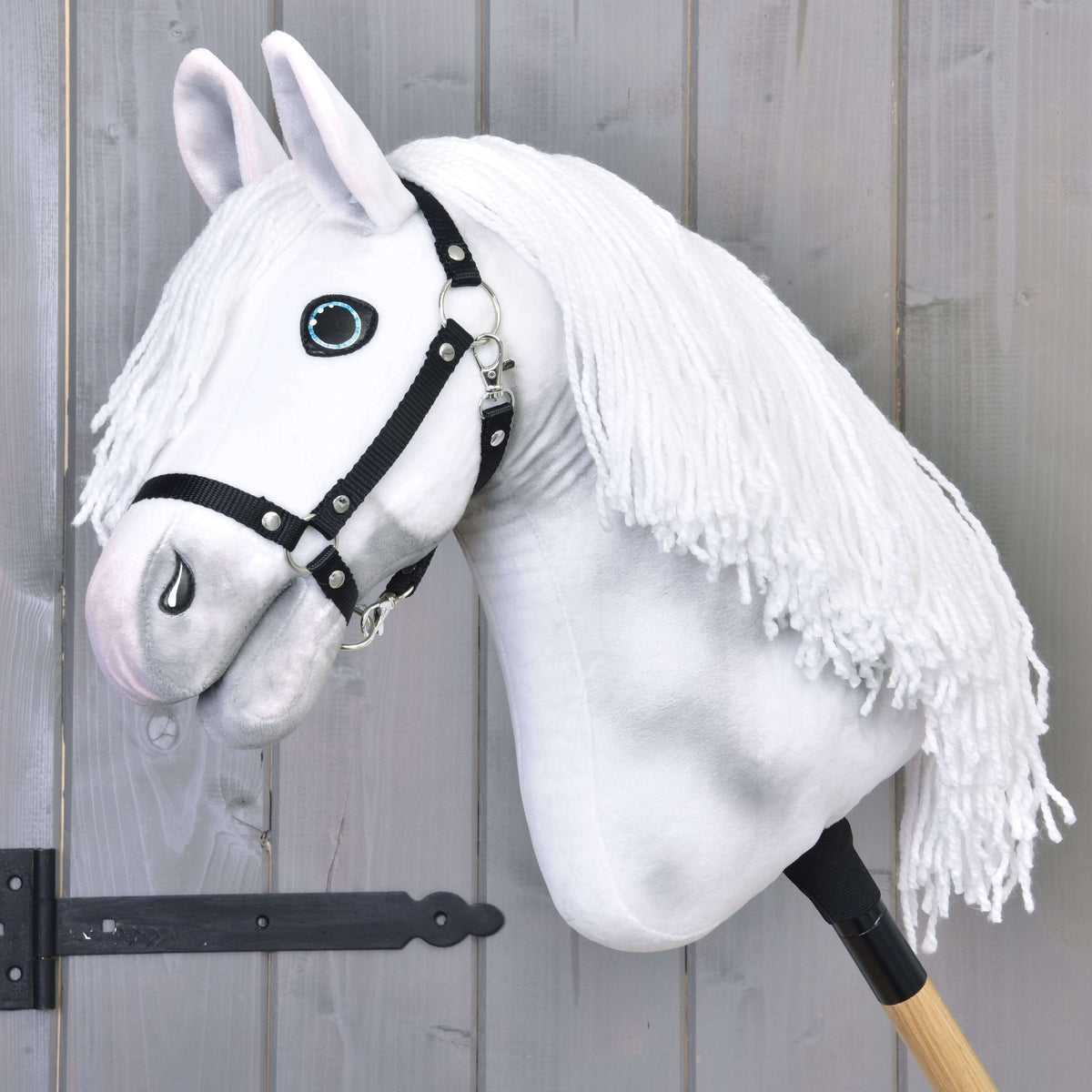 Hobby Horse Elektra med svart grimma från LarDen, ett vitt plyschhuvud med grå skuggning, blå ögon och lång vit man av garn