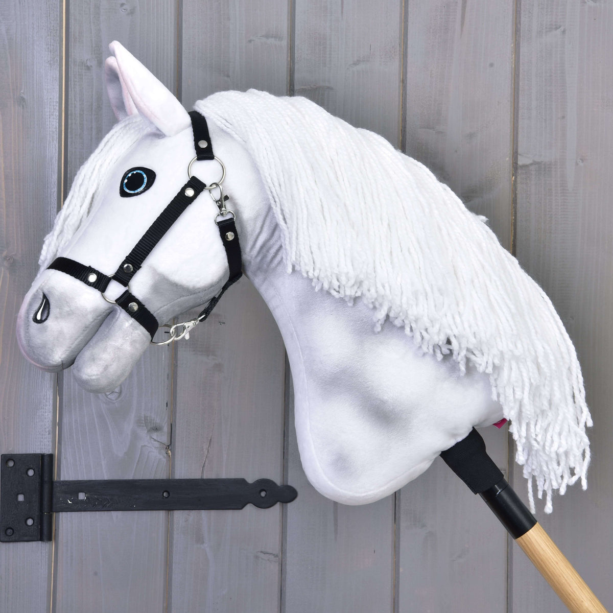 Hobby Horse Elektra med svart grimma med sänkt huvud, tjock vit man av garn som faller över halsen