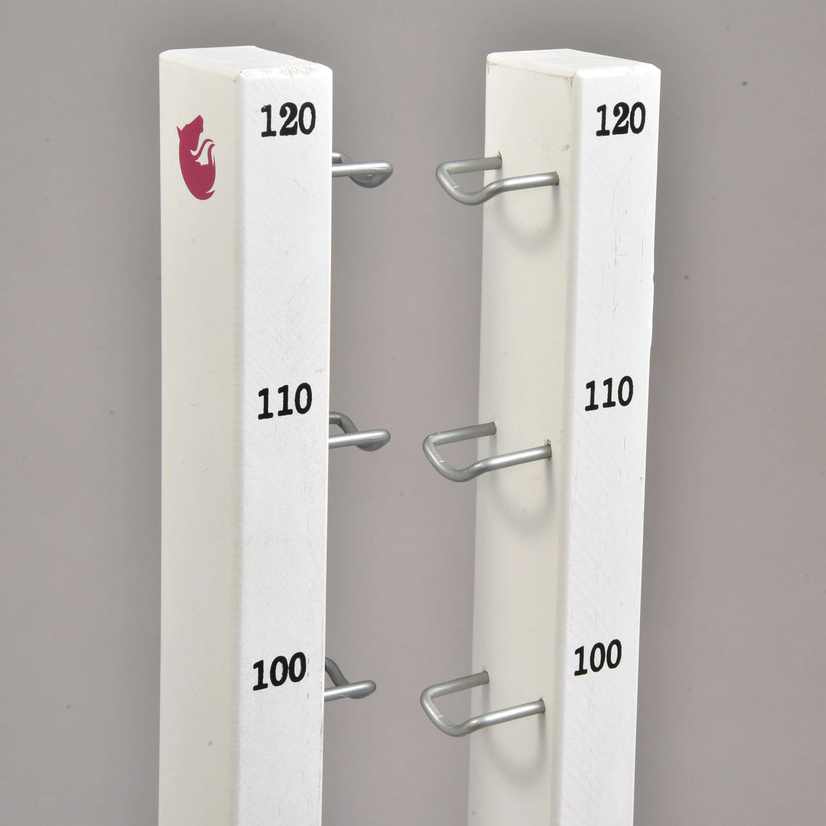 Tops of the two tall stands with 100, 110 and 120 cm marks, metal hooks and a small pink horse logo