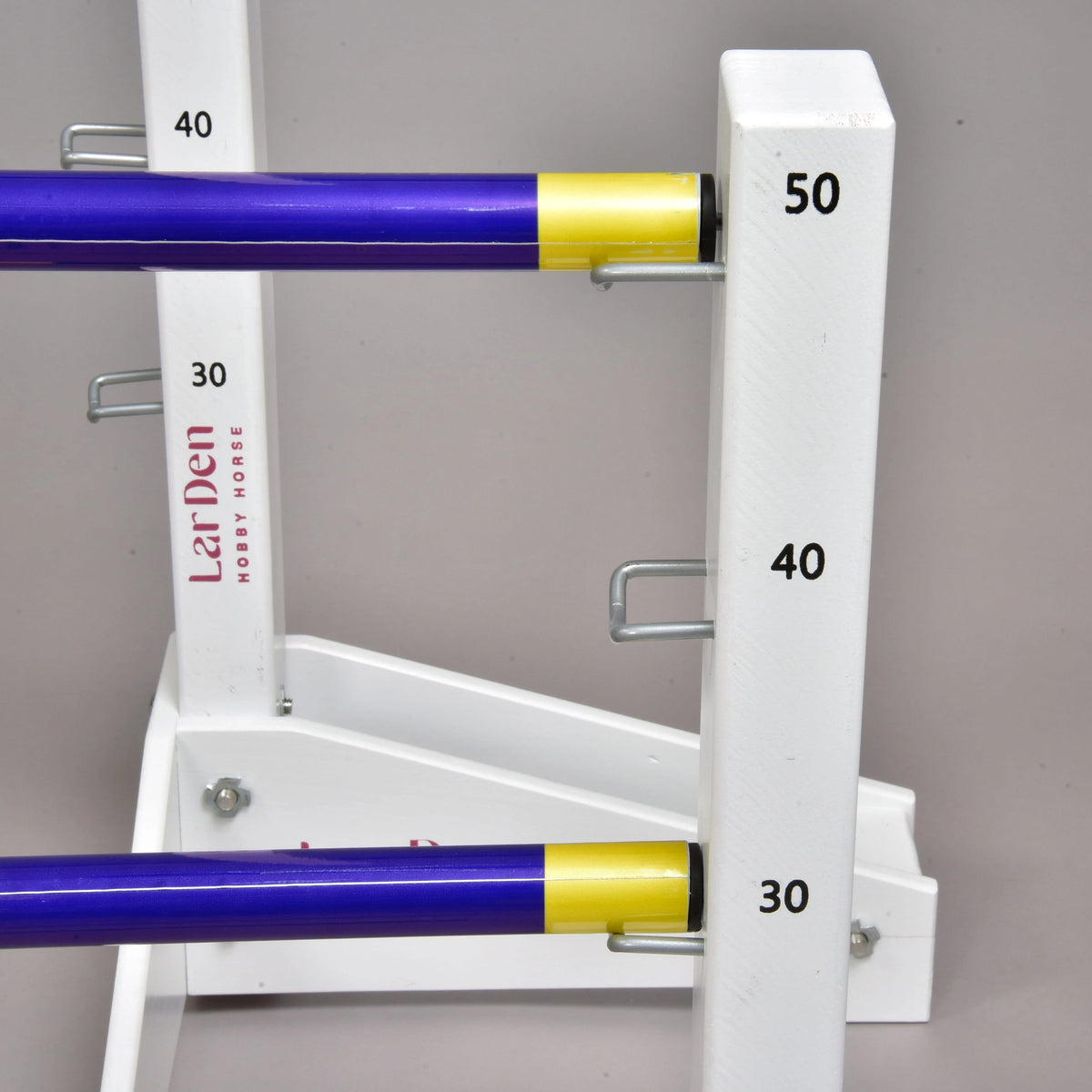Blue poles with yellow ends on the hooks of a low stand at 30 and 50 cm, the LarDen print on the tall stand behind
