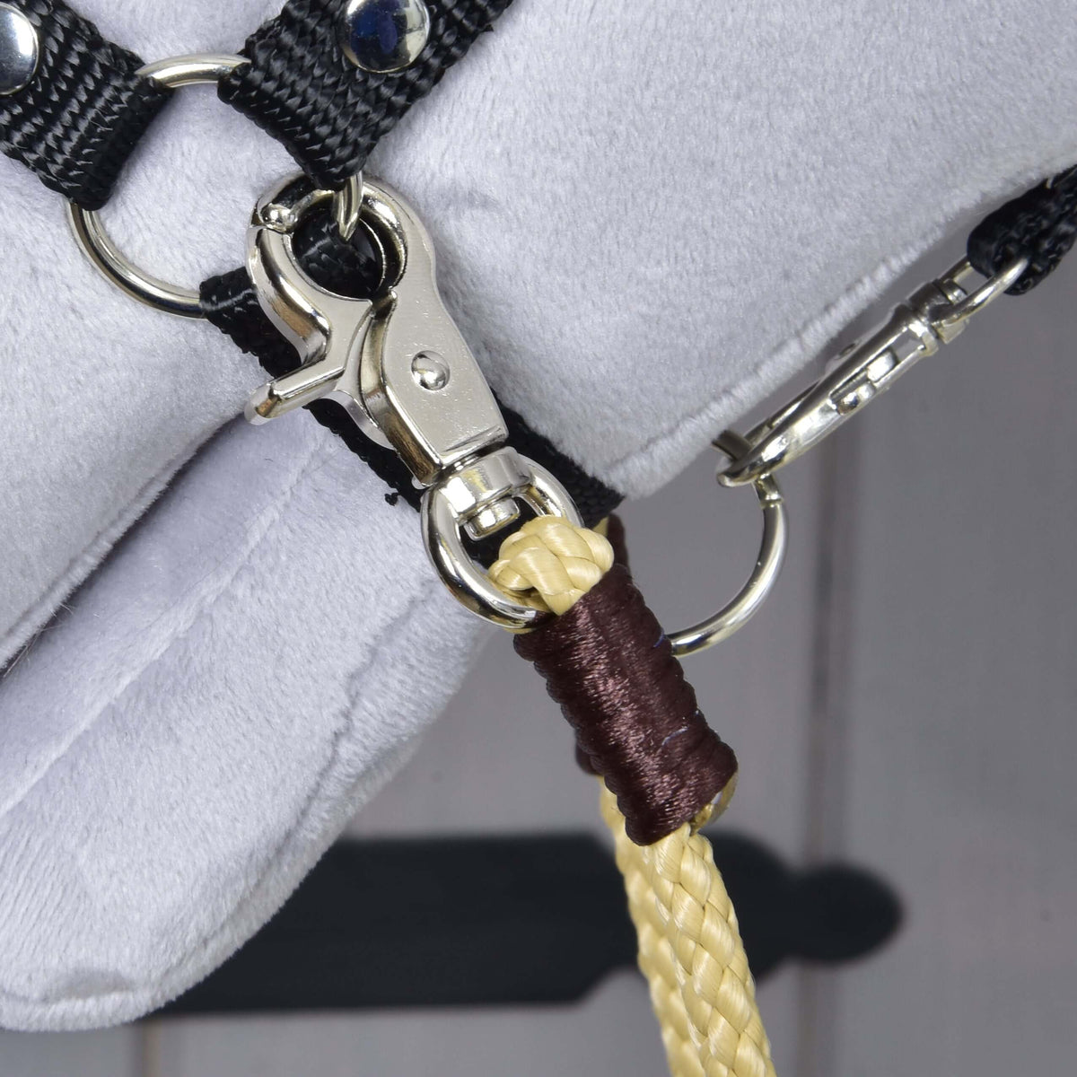 Närbild av Hobby Horse westerntyglar Dakota: silverfärgad karbinhake i grimmans ring och mörkbrun lindning på sandfärgat rep