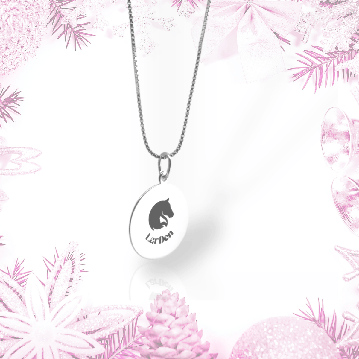 Silver necklace with LarDen pendant: a round disc with a horse head logo on a box chain, framed by pink frosted decorations