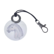 Reverse of the round reflective keychain with a drawing of a grey Hobby Horse on a stick with a curly mane