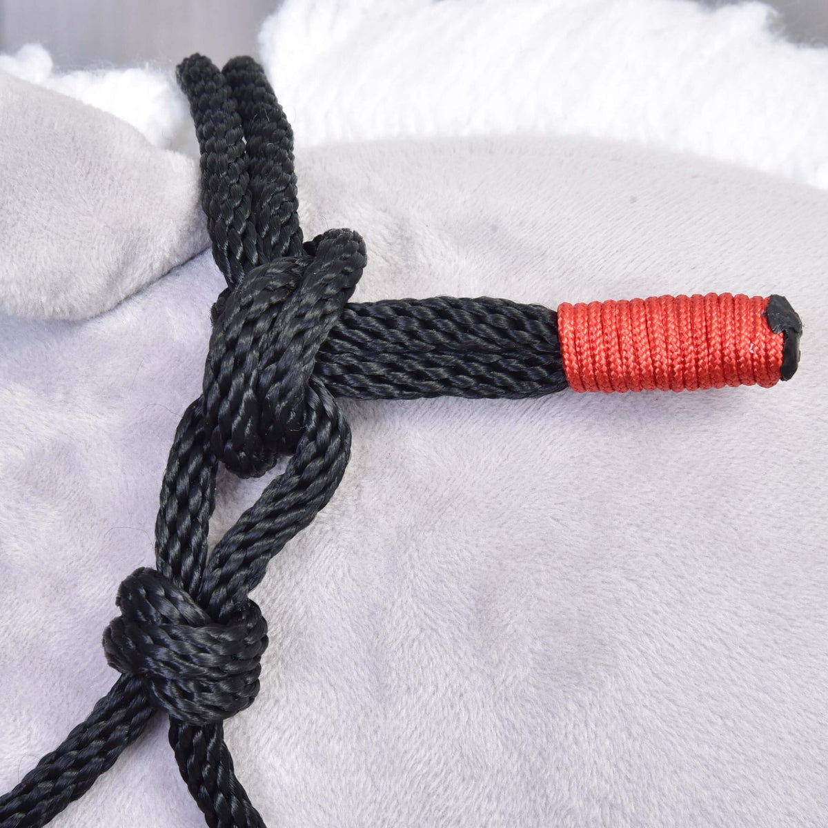 Close-up of the knotted black rope halter with a red wrapped end from the Hobby Horse Rope set Spark