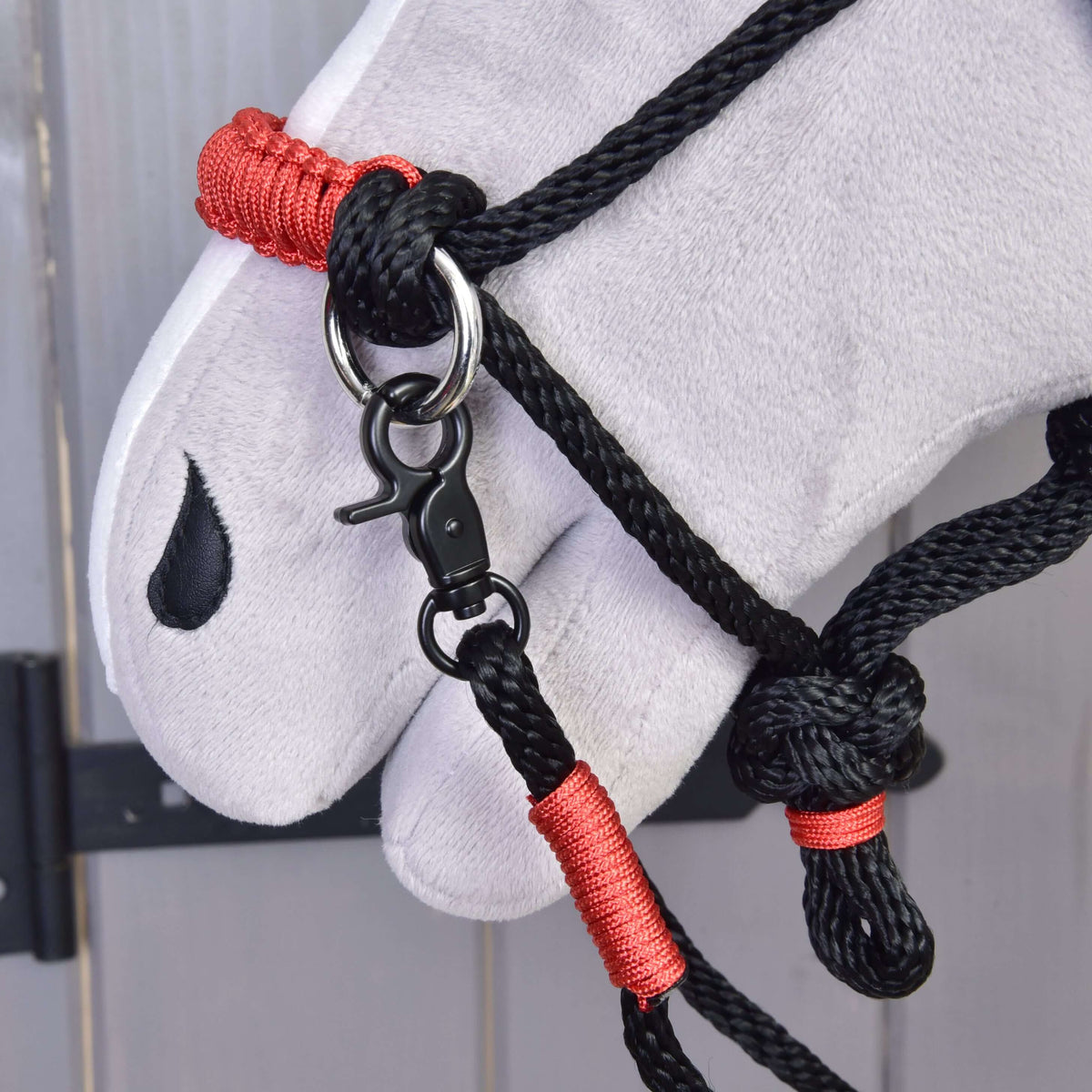 Hobby Horse Rope set Spark close-up: red braided noseband, black snap hook and red wraps on the black rope