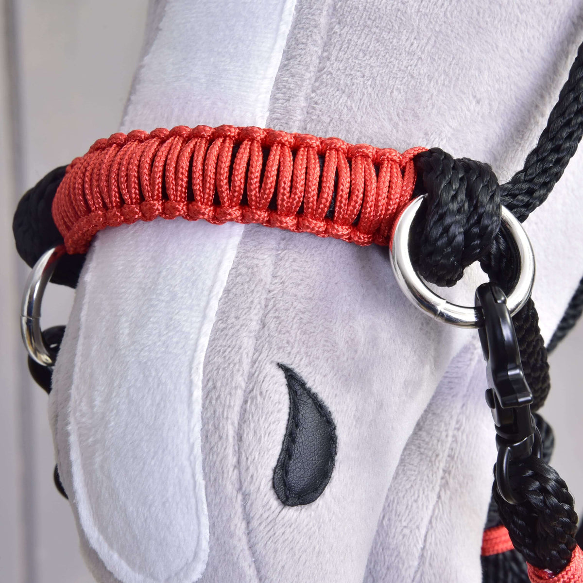 Close-up of the red braided noseband with silver rings on the Hobby Horse Rope set Spark halter