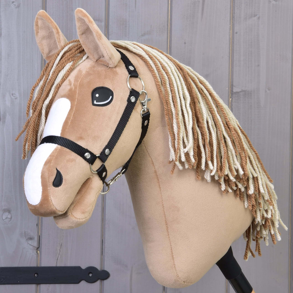 Hobby Horse Bren med svart grimma från LarDen, ett ljusbrunt käpphästhuvud i plysch med vit bläs och man av brunt och krämfärgat garn