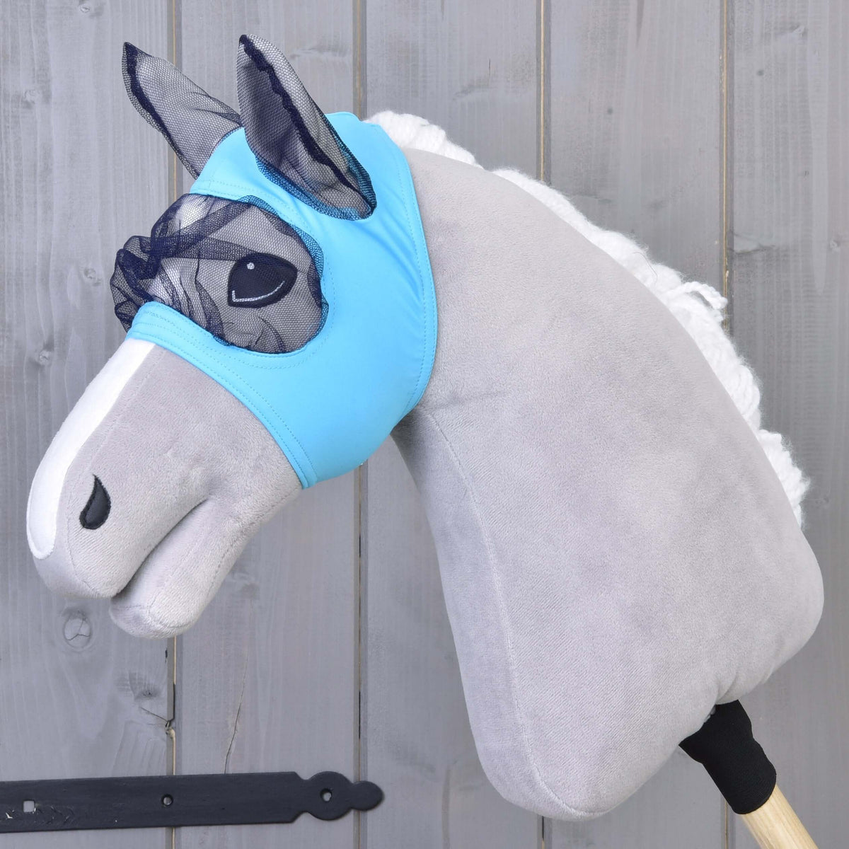 Hobby Horse flugmask från LarDen, ljusblått stretchtyg med marinblått nät över ögon och öron, på ett grått käpphästhuvud i plysch