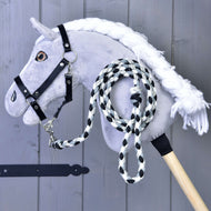 A grey plush Hobby Horse in a black halter with the black, white and grey braided lead rope clipped on and coiled