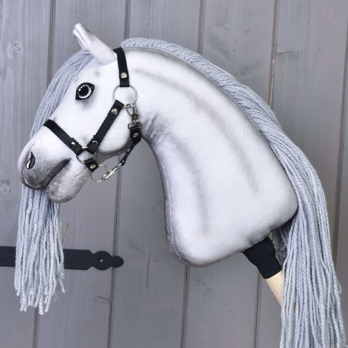 Hobby Horse enhörning Silver i profil med svart grimma av vävt band, gråskuggad hals och lång grå man av garn, på en käpp