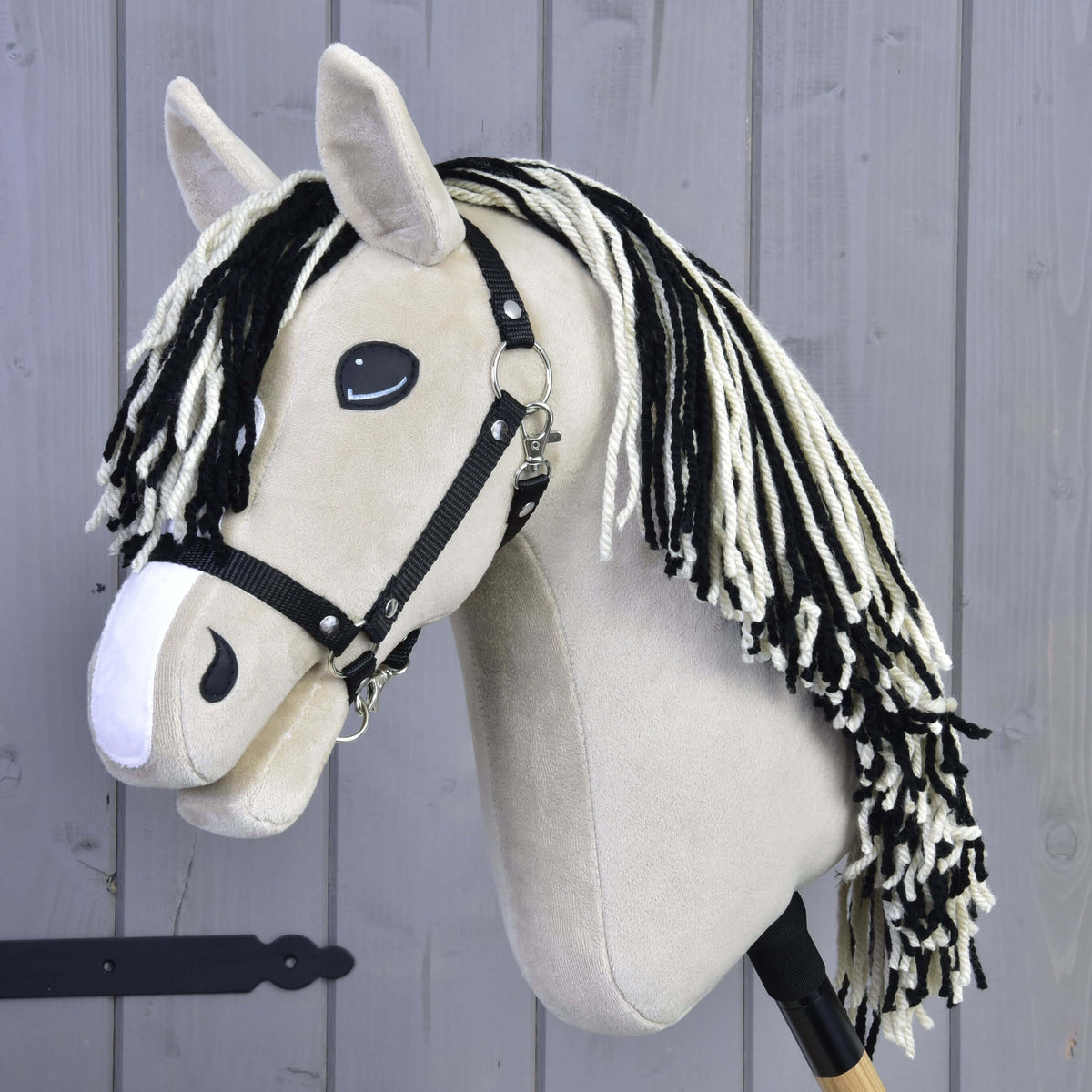 Hobby Horse Aurora with Black Halter by LarDen, a cream plush head with a white blaze and black and white yarn mane