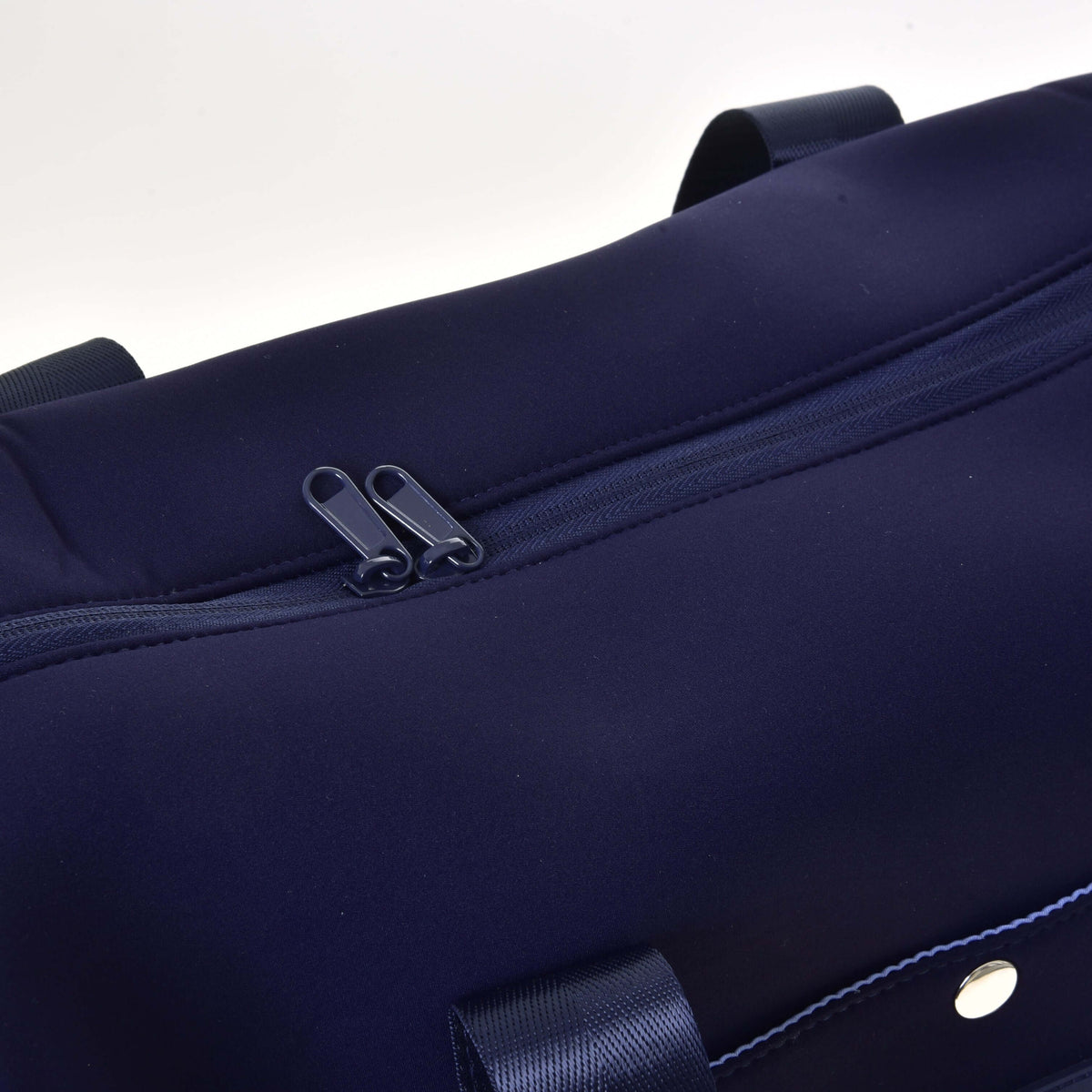 Close-up of the two navy zip pullers on the main compartment of the Hobby Horse Sports bag, smooth neoprene