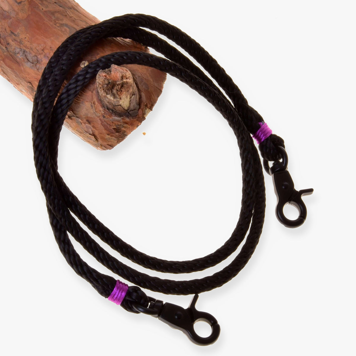Hobby Horse Reins Violette by LarDen, black braided rope reins with purple wraps and black snap hooks over a branch