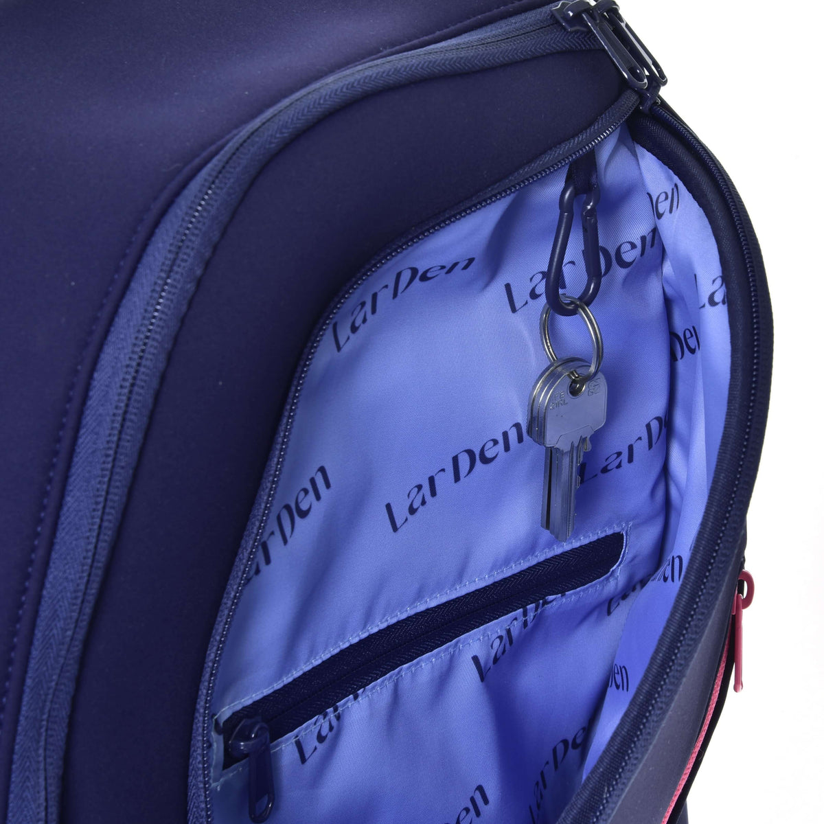 Open front pocket of the Hobby Horse Backpack with a key on a carabiner clip and an inner zip pocket in the LarDen lining