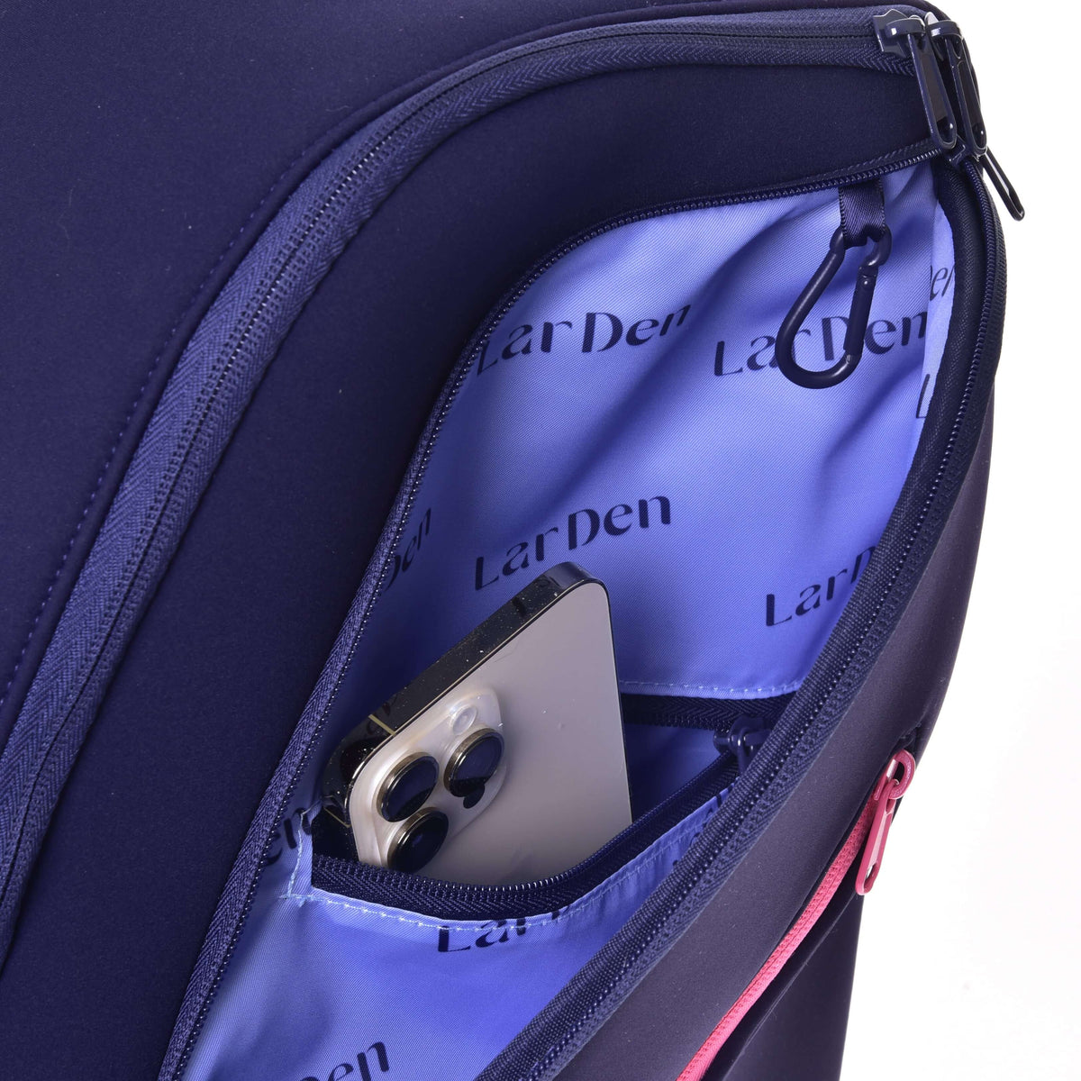 Smartphone tucked into the inner pocket of the Hobby Horse Backpack front compartment, lilac lining with dark lettering