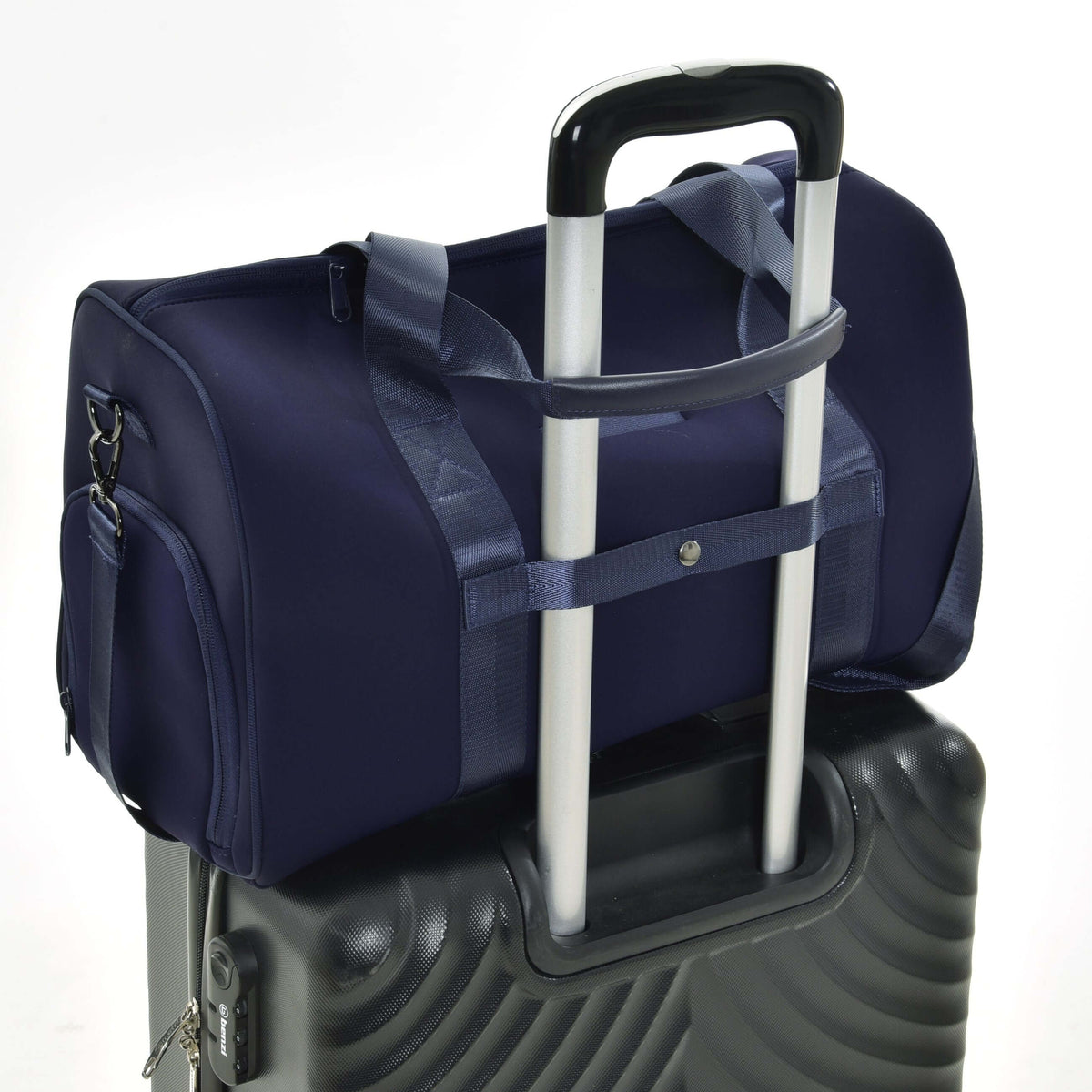 Navy Hobby Horse sports bag slid over the handle of a black hard-shell suitcase by its back strap