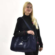 Blonde girl in a black sweatshirt carrying a navy Hobby Horse sports bag with a white LarDen logo over her shoulder
