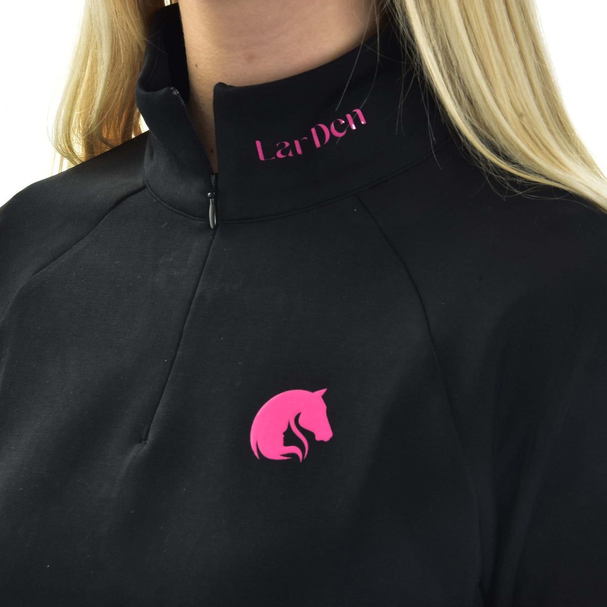 Närbild av Hobby Horse sweatshirten LarDen på en flicka: ståkrage med stängd dragkedja, rosa text och rosa hästlogga