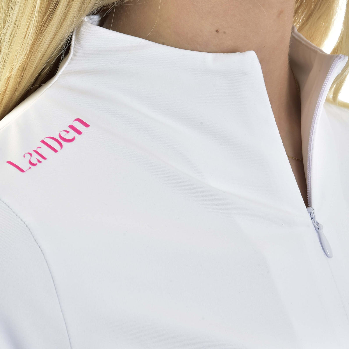 Närbild av rosa LarDen-text bredvid den vita kragen med dragkedja på Hobby Horse T-shirten Premium