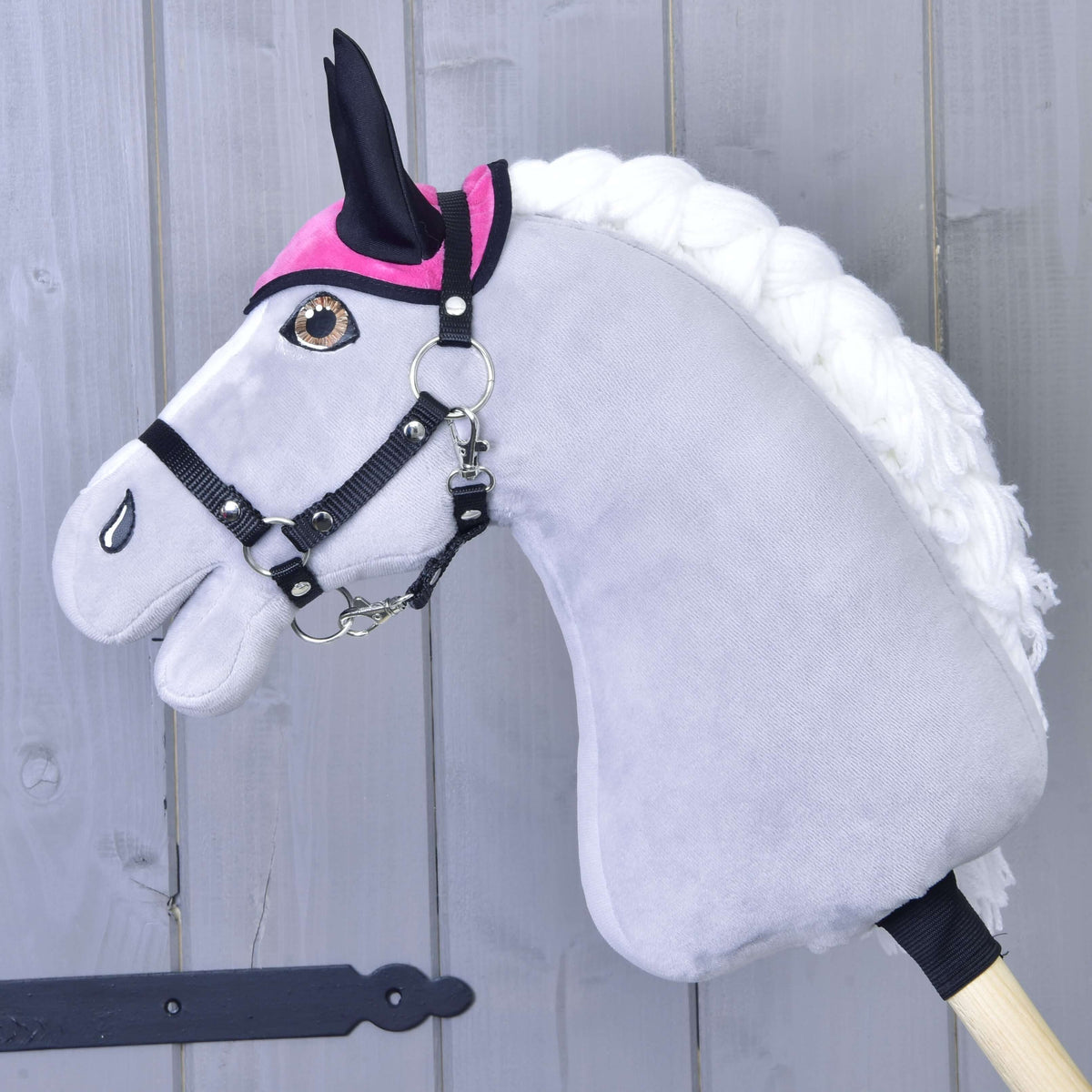 Grey Hobby Horse in a black halter wearing only the hot pink ear bonnet with black ears