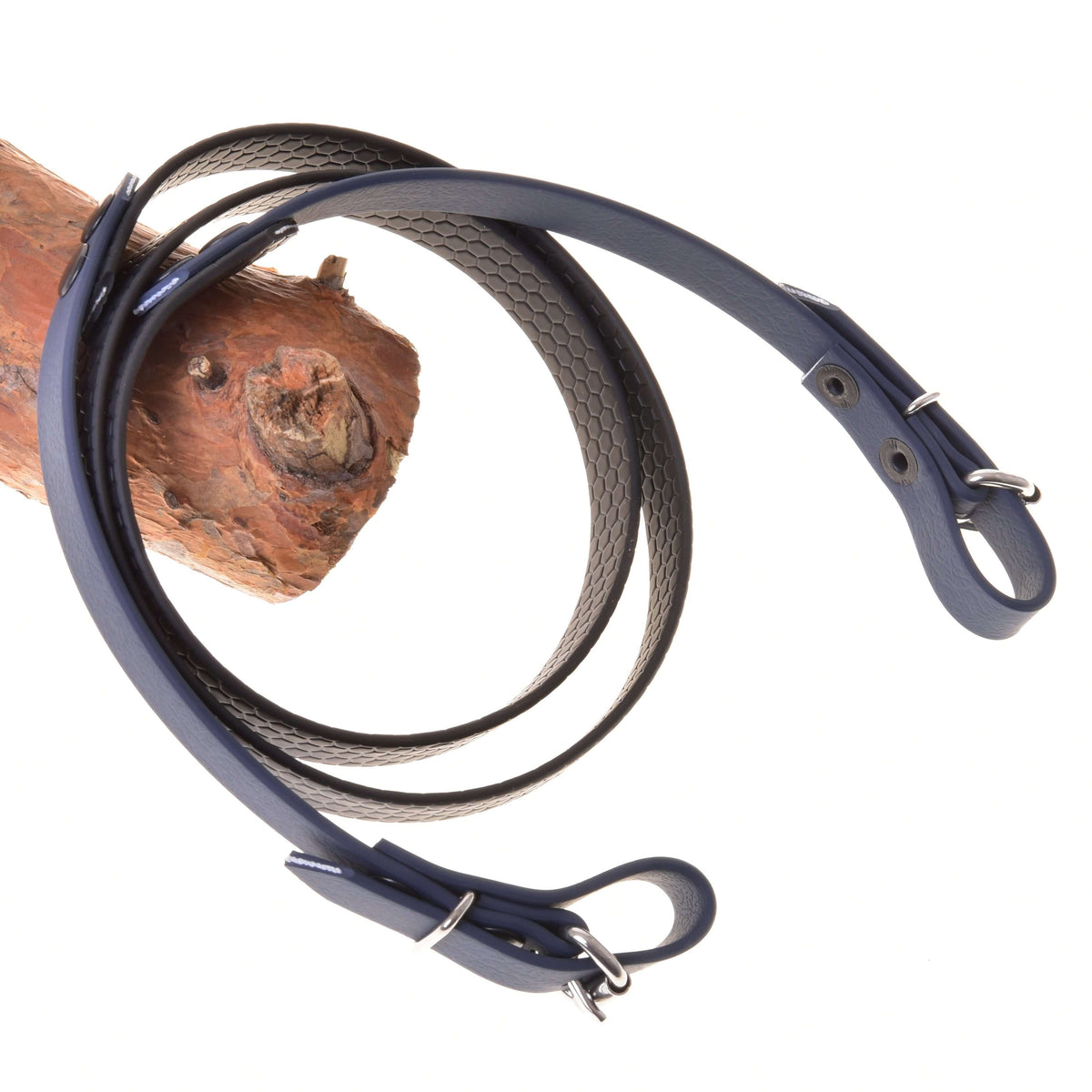 Gummerade tyglar antracit för Hobby Horse från LarDen med greppvänligt bikakemönster, ändar med spännen och karbinhakar, på en gren