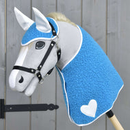 Grey plush Hobby Horse in a black halter wearing the blue curly blanket and ear bonnet with white heart and white ears