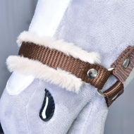 Close-up of the brown webbing noseband with soft beige fur and a silver rivet on a grey plush Hobby Horse
