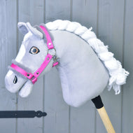 A grey plush Hobby Horse with a white braided mane and brown eyes wears the bright pink halter with grey fur