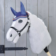 Grey plush Hobby Horse with a white blaze and black halter wearing the navy crocheted ear bonnet with orange piping