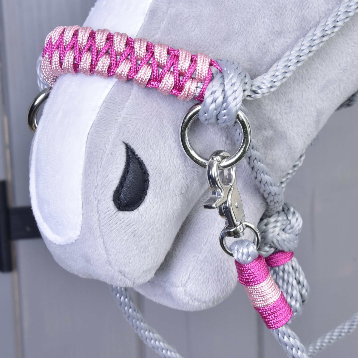 Close-up of the pink braided noseband, snap hook and pink wrapped rein end of Rope set Rosie on a Hobby Horse