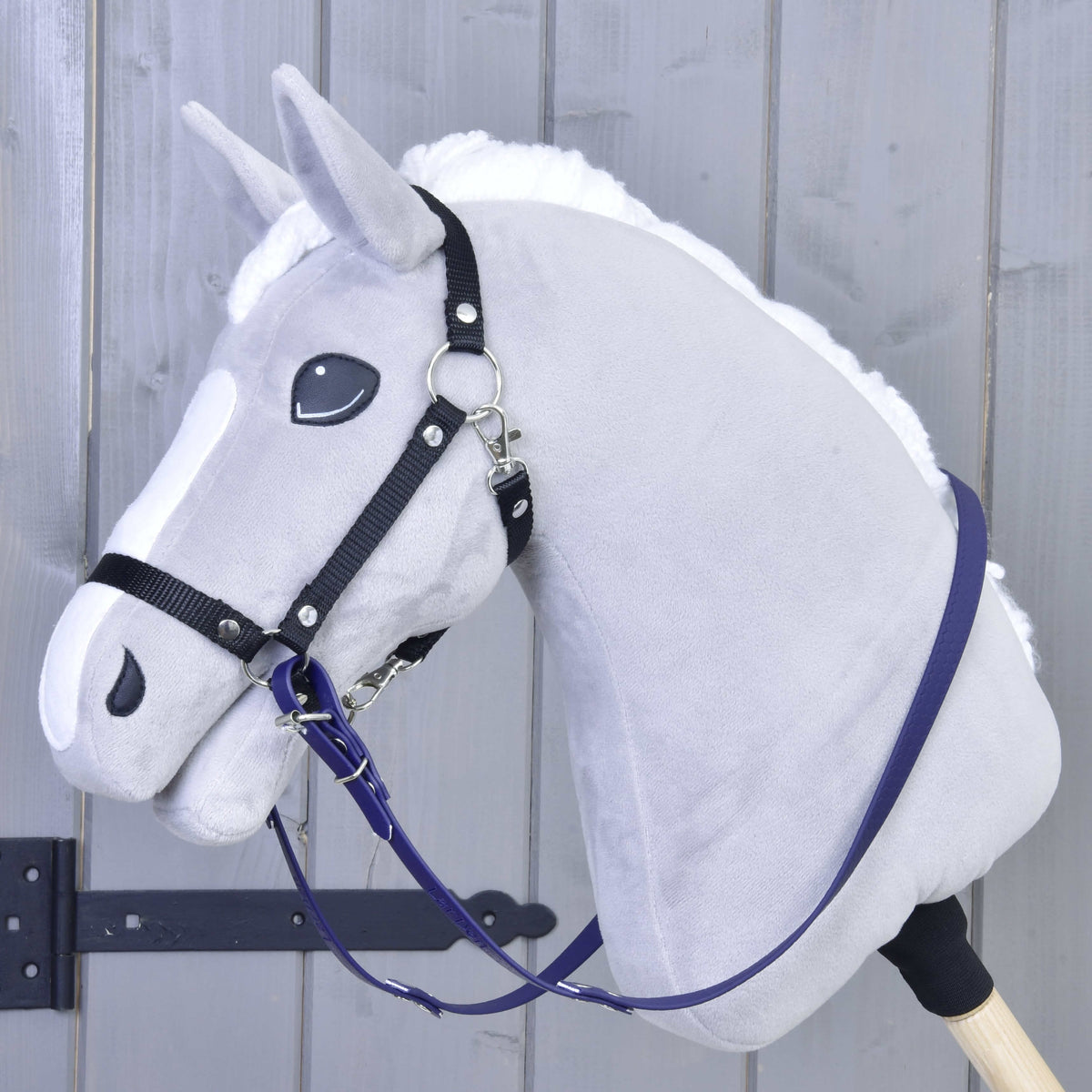 Grey plush Hobby Horse with a black halter and dark purple rubberized reins hanging along its neck