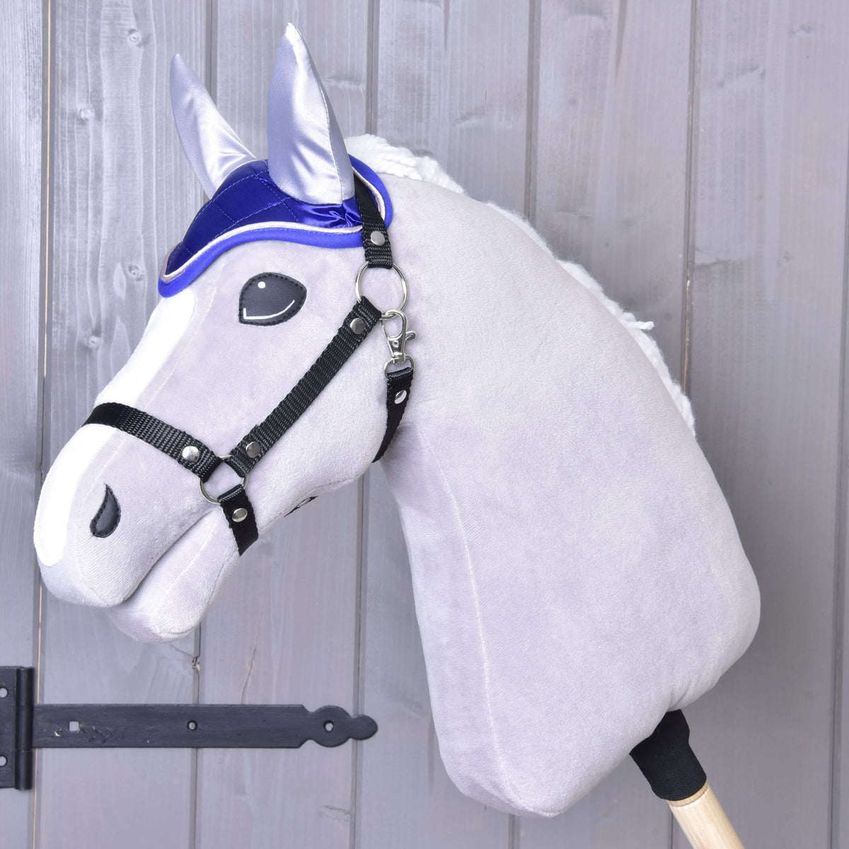 Grey plush Hobby Horse with a white mane and black halter wearing the royal blue satin Ear Bonnet DeLuxe Blue