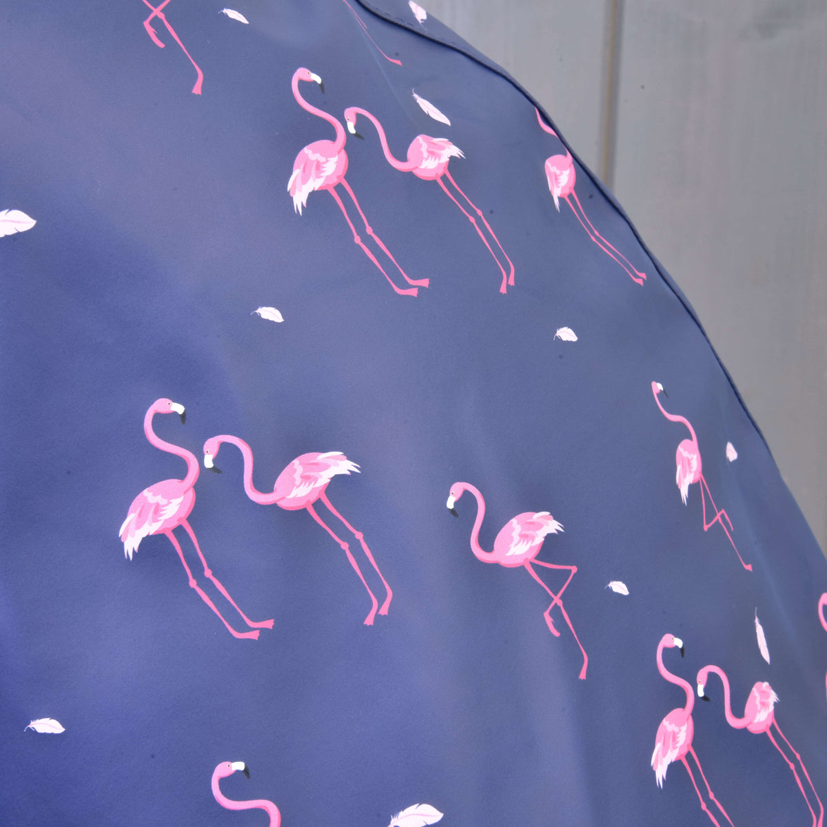 Close-up of the pink flamingo and white feather print on the blue-violet raincoat fabric for a Hobby Horse