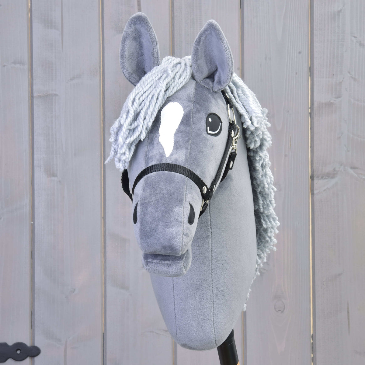Hobby Horse Grace framifrån med vit stjärna, ljusgrå pannlugg av garn och svart grimma