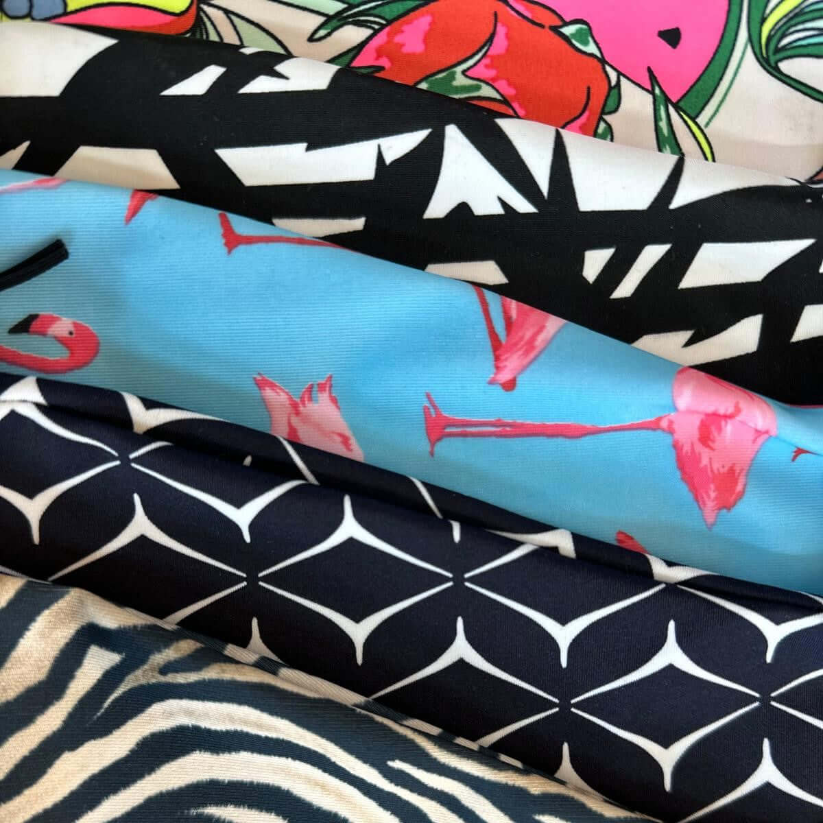 Fem staplade tyger: tropiska frukter, svartvitt abstrakt, rosa flamingor på blått, marinblått geometriskt och zebra
