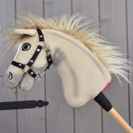 Hobby Horse Ivory Dream i vänsterprofil, svart grimma med silvernitar och blond man som böljar över den krämvita halsen