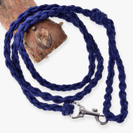 Hobby Horse grimskaft Knitted Royal Blue från LarDen, ett flätat grimskaft av paracord med silverfärgad karbinhake, hoprullat bredvid en stock