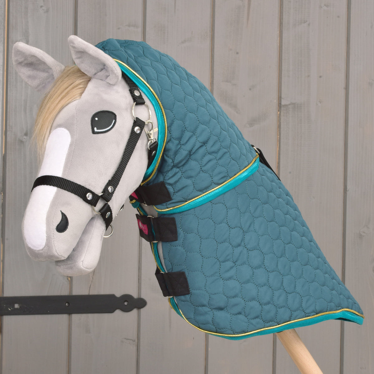 Grey Hobby Horse in a black halter wearing the Lagoon blanket and neck cover in dark teal, closed with three black straps
