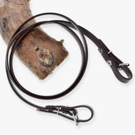 Hobby Horse Reins Light brown by LarDen, smooth brown rubberized reins with buckle ends, looped over a pine branch