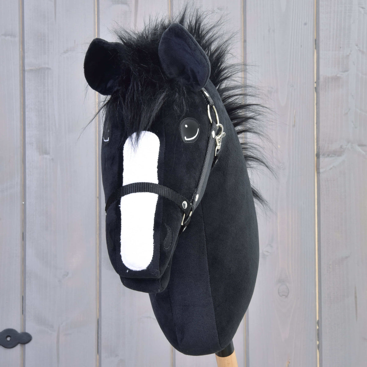 Hobby Horse Loki framifrån med vit bläs, rufsig svart pannlugg av päls och svart grimma