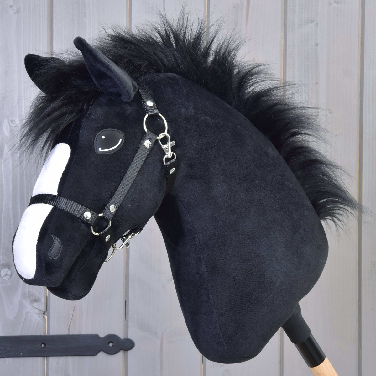Hobby Horse Loki med svart grimma från LarDen, ett svart käpphästhuvud i plysch med vit bläs och fluffig svart man av fuskpäls