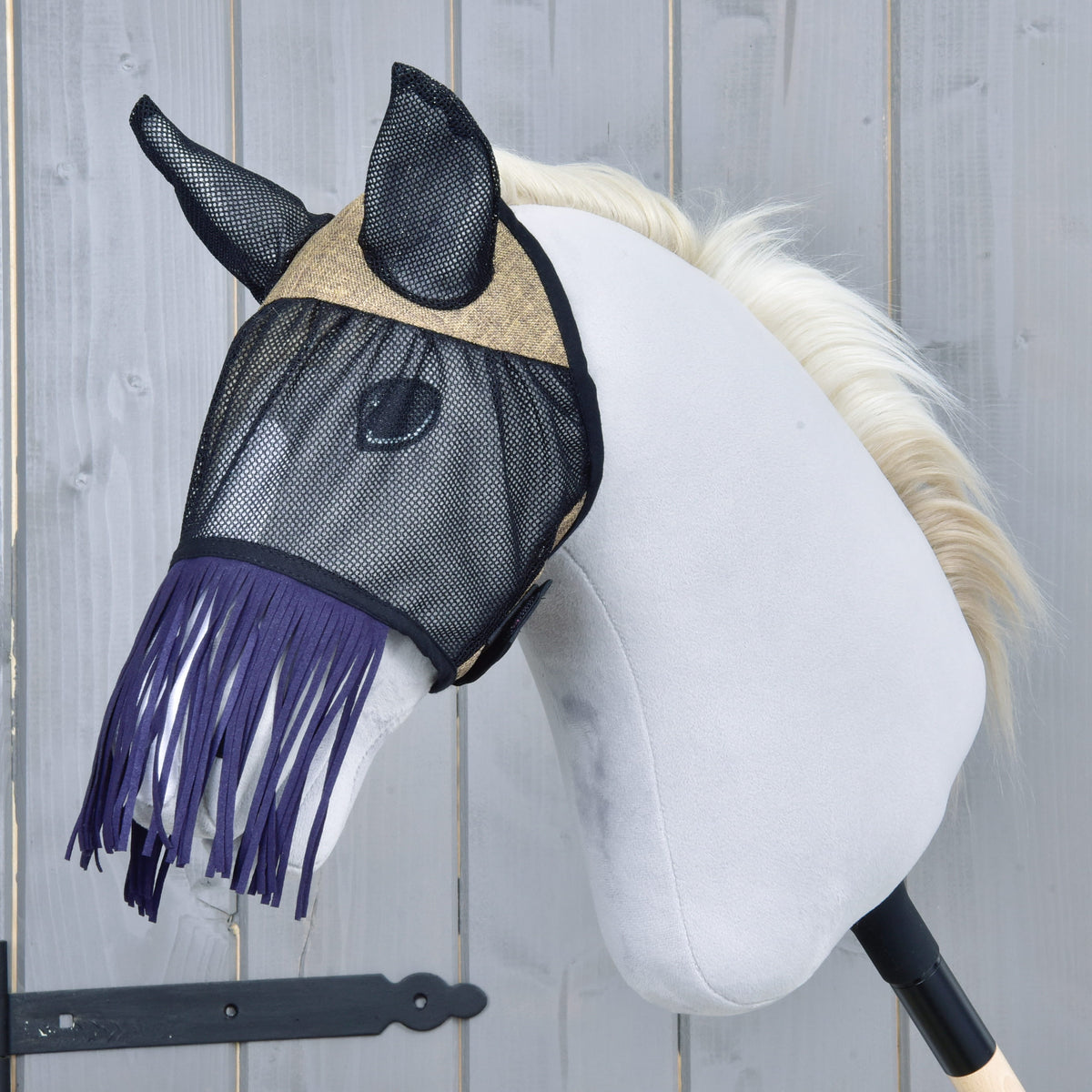 LarDen flugmask De Luxe Mona i svart nät med beige vävd pannpanel och mörklila nosfrans på en grå käpphäst