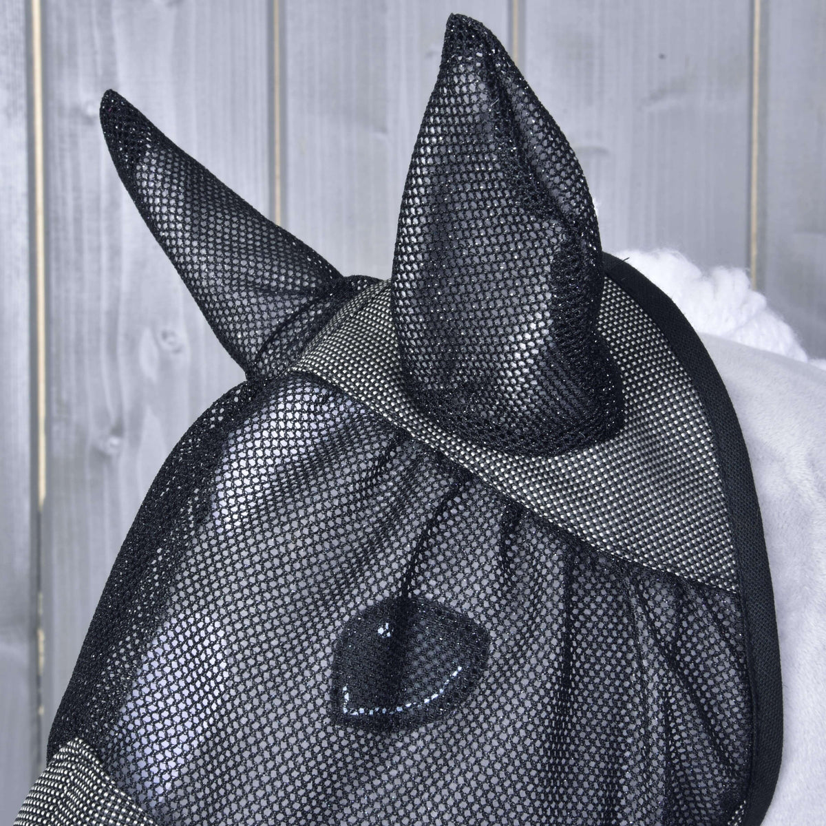 Närbild av de svarta nätöronen och ögonnätet på Hobby Horse flugmask De Luxe Grey, med käpphästens öga synligt under