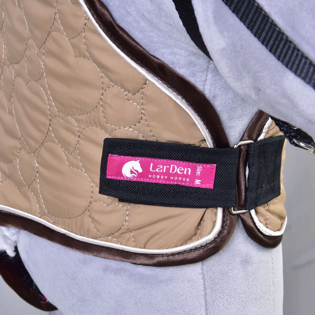 Close-up of the beige heart-quilted neck cover fastened with the LarDen Velcro strap under the neck of a grey Hobby Horse