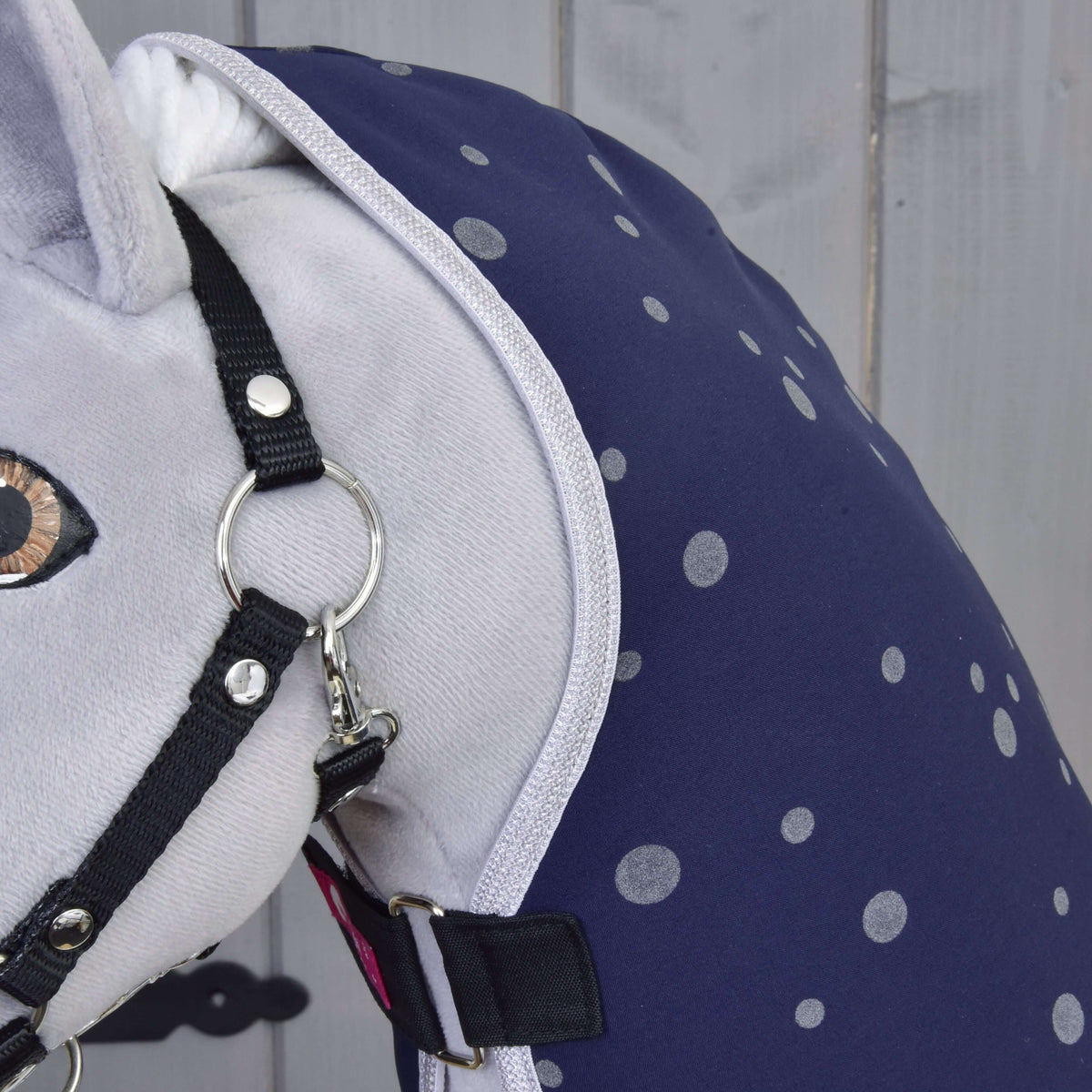 Close-up of the grey polka dots and light grey trim of the Night Sky blanket at the neck, beside the halter ring