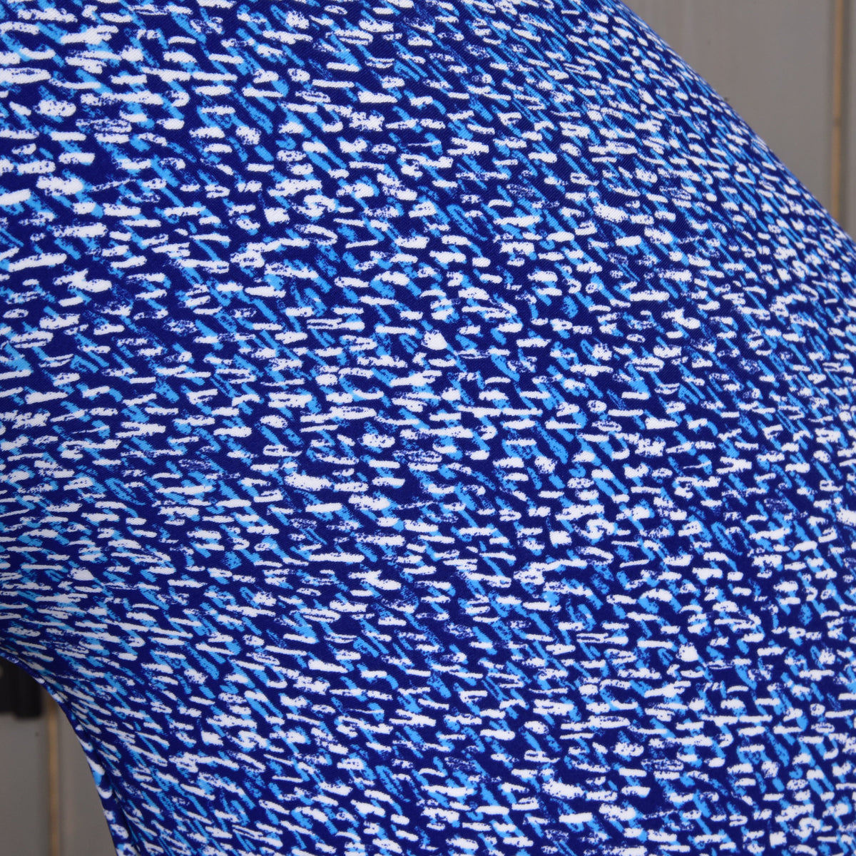 Close-up of the See fabric: short white and sky blue brush strokes on a deep royal blue background