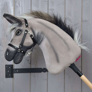 Hobby Horse Donkey Olin in left profile with dark shading on the grey neck, a black muzzle and a fluffy grey-black mane